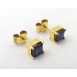 Gilt metal stud earrings set with blue stones. Please Note - we do not make reference to the