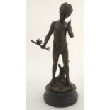 A 20thC cast scultpure depicting a young boy holding a branch with two small birds, Charmeur after