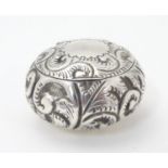 A Victorian silver pill box with embossed decoration, hallmarked Birmingham c. 1898, maker