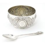 A Victorian silver Christening bowl and spoon with Egyptian revival decoration of pharaoh heads