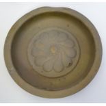 A 17th / 18thC brass alms dish with gadrooned central boss of flower form. Approx. 11 1/4"