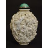 A Chinese snuff bottle decorated with a profusion of male figures moulded in relief. The lid with an
