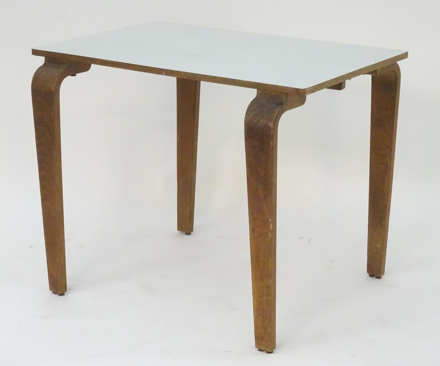 A mid 20thC table with a rectangular top above shaped tapered oak legs. 36" long x 24" wide x 29"
