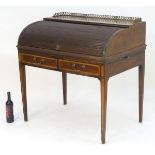 A late 19thC mahogany tambour fronted desk with satinwood cross banding and a raised brass