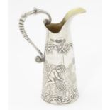 A Continental silver miniature cream jug decorated with Bacchanalian putti, probably Dutch, with