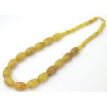 A vintage necklace of graduated butterscotch coloured amber style beads. Approx 20" long Please Note