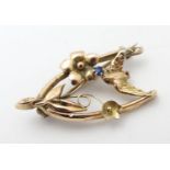 An early 20thC 9ct gold sweetheart brooch set with wishbone swallow and floral decoration with