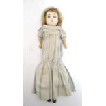 Toy: A wax headed doll with blue eyes, painted features, brown hair, composite forearms and