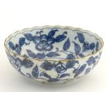 A Chinese blue and white bowl with a lobed rim, decorated with flowers and foliage. Character