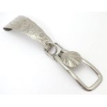 A late 19thC / early 20thC silver plate skirt lifter with engraved decoration. Approx. 3" long