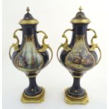 A matched pair of Sevres style lidded urn vases on mounted bases, with cobalt blue bodies with