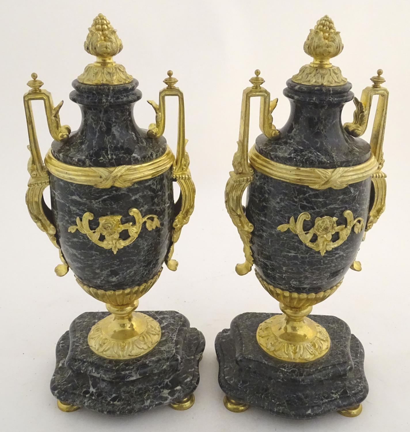 A pair of late 19thC grey marble garnitures of urn form with gilt metal handles and mounts.