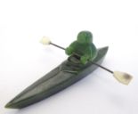 A green jade carving in the form of an Inuit figure in a canoe. Approx. 5" long. Please Note - we do