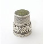 A silver thimble decorated with harp and shamrock detail with hardstone tip, hallmarked Birmingham