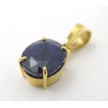 A 9ct gold pendant set with oval sapphire 1" long Please Note - we do not make reference to the