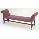 A late 18thC mahogany window seat with scrolled arms and studded upholstery above tapering legs