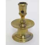 A 17thC brass spun candlestick with trumpet base and broad drip pan. Approx. 5" high. Please