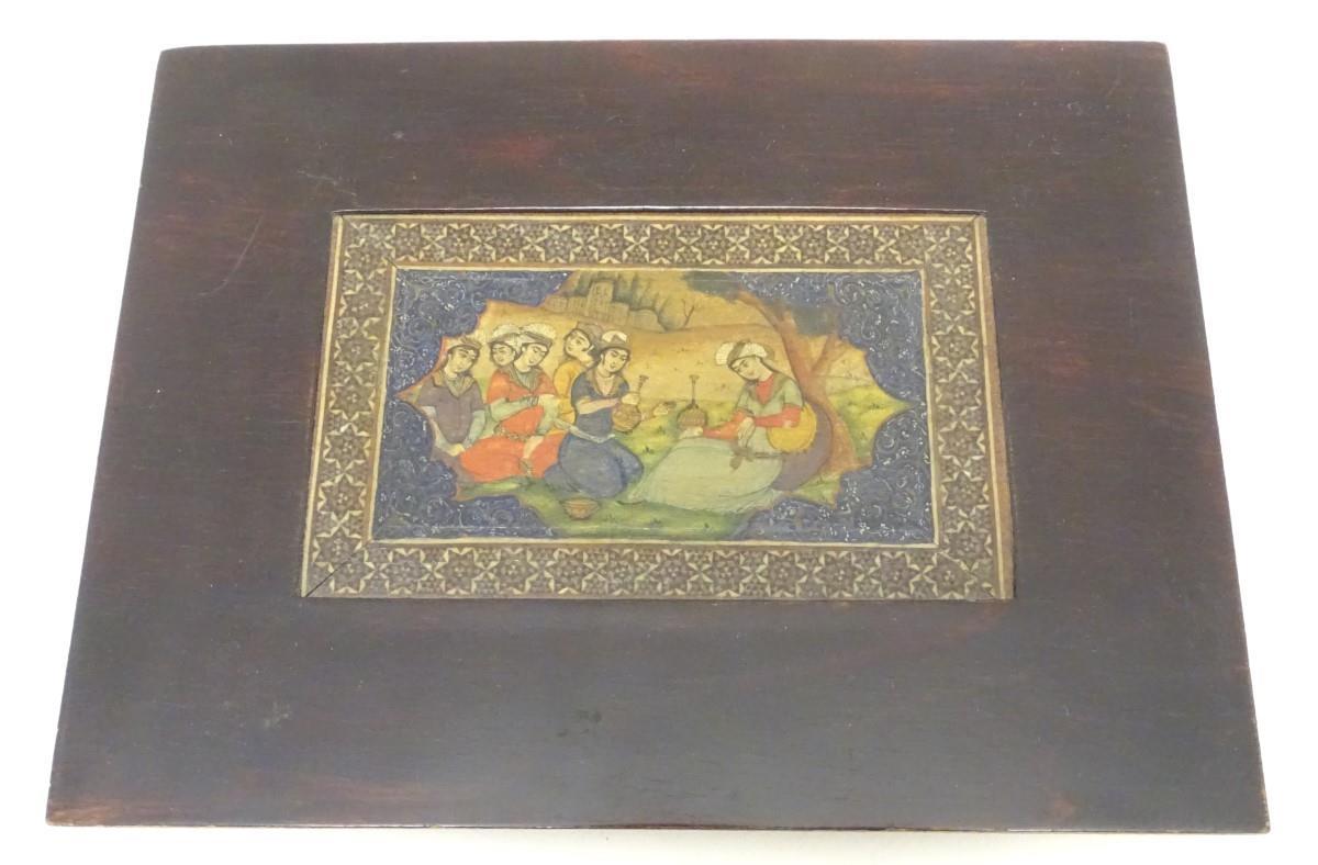 A 19thC Indian painting on a framed sheet bone, depicting a figures seated in a landscape. Approx. 3