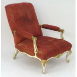 A Victorian low armchair with a painted frame, swept arms and a shaped apron, standing on cabriole