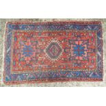 Carpet / rug: A red and blue ground rug decorated with geometric and cruciform patterns and stylised