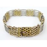 A white and gilt metal chainlink bracelet approx 7" long Please Note - we do not make reference to