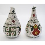 A pair of wooden pear shaped decorations with beadwork featuring Buddhist symbols of good luck.