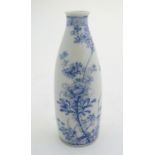 An Oriental blue and white vase of narrow form with floral and foliate decoration. Approx. 7 1/4"