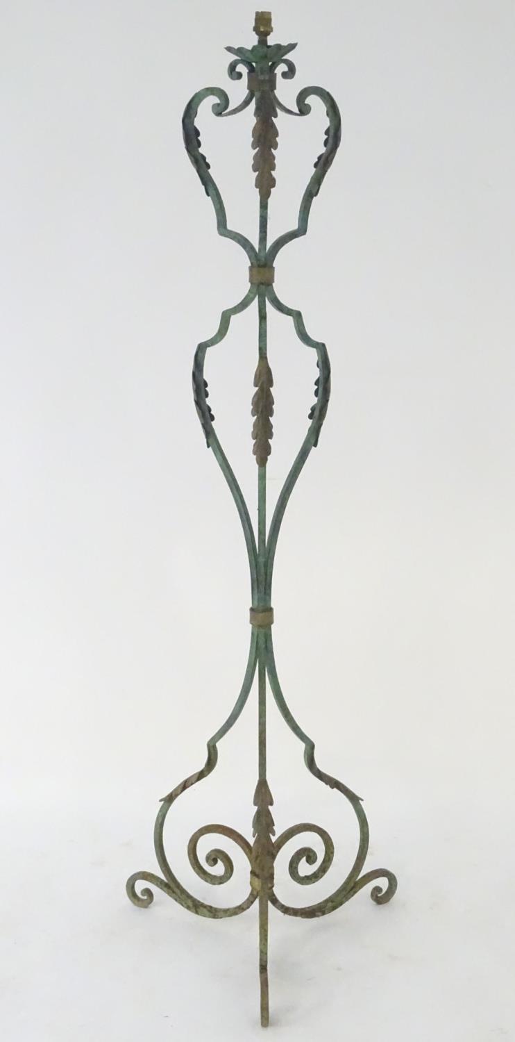 A late 19th / early 20thC wrought iron standard lamp with a verdisgris finish and gilt foliate