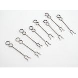 A set of 8 white metal cocktail / olive forks. 3" long Please Note - we do not make reference to the