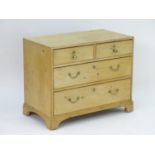 A late 19thC pine chest of drawers comprising two short drawers with brass knob handles above two