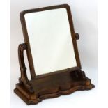 A late 19thC mahogany dressing mirror with a rectangular moulded frame and carved supports above a