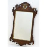 A Regency mahogany mirror with a carved pierced frame depicting a golden bird above a gilt wood