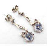 A pair of silver drop earrings in the Art Nouveau style with scroll and flower decoration with