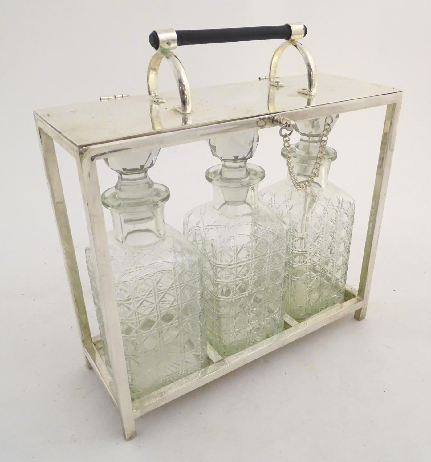 A Dr Christopher Dresser style tantalus with provision for three decanters. Approx. 11 1/2" high