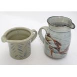 Two studio pottery jugs, one with stylised fish decoration, the other with brushwork chevron detail.
