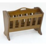 A mid 20thC oak Alan 'Acornman' Grainger magazine rack with shaped ends and slatted dividers with