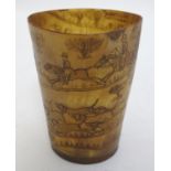 A 19thC horn beaker with naive scrimshaw decoration depicting a stag hunting scene, with figures