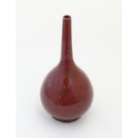 A Chinese globular vase with a slender, elongated neck with a sang de boeuf glaze. Approx. 17 1/