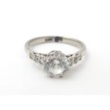 An 18ct white gold ring set with central brilliant and 3 graduated diamonds to each shoulder. Ring