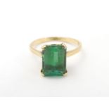A yellow metal ring set with baguette cut green stone. Ring size approx K 1/2 Please Note - we do