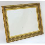 A large mirror with a moulded gilt surround and bevelled edge. 44" wide x 34" high. Please Note - we
