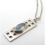 A Rennie Macintosh inspired silver pendant set with blue stone, with silver box link chain.