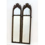 A pair of 18thC walnut mirrors with shaped tops, carved shell decoration and the mirrors having