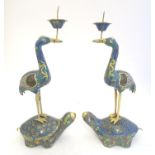 A matched pair of 19thC cloisonne candle holders, each formed as a stylised crane upon the back of a