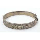 A silver bracelet of bangle form with engraved acanthus scroll decoration. hallmarked London 1962