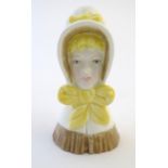 A Royal Worcester figural candle snuffer modelled as a young girl. Marked within. Approx. 3 1/2"