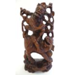 An Oriental hardwood carving depicting a figure and a beast. Approx. 12" high. Please Note - we do