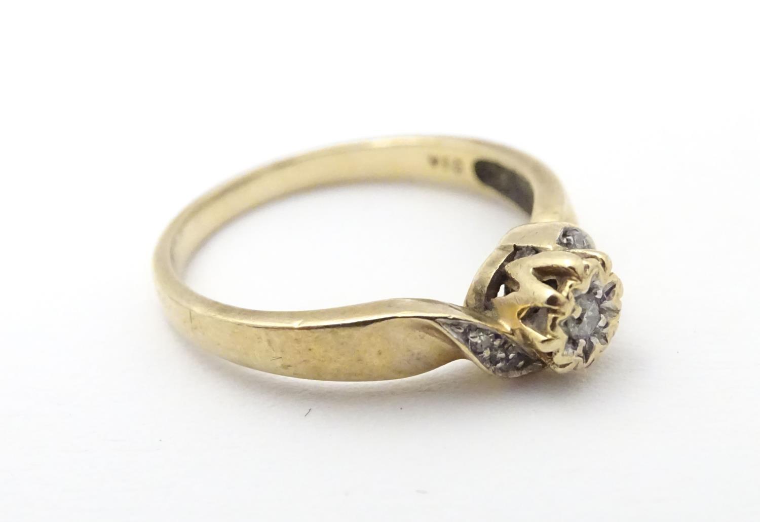 A 9ct gold ring set with central diamond flanked by diamonds to shoulders. Ring size approx J 1/2 - Image 4 of 6