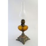 An early-20thC French oil table lamp, with 'Matador' burner, the amber glass reservoir supported