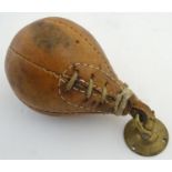 A 20thC leather boxing gym punch ball, with brass loop and ceiling mount. Approx. 7 1/2" long Please